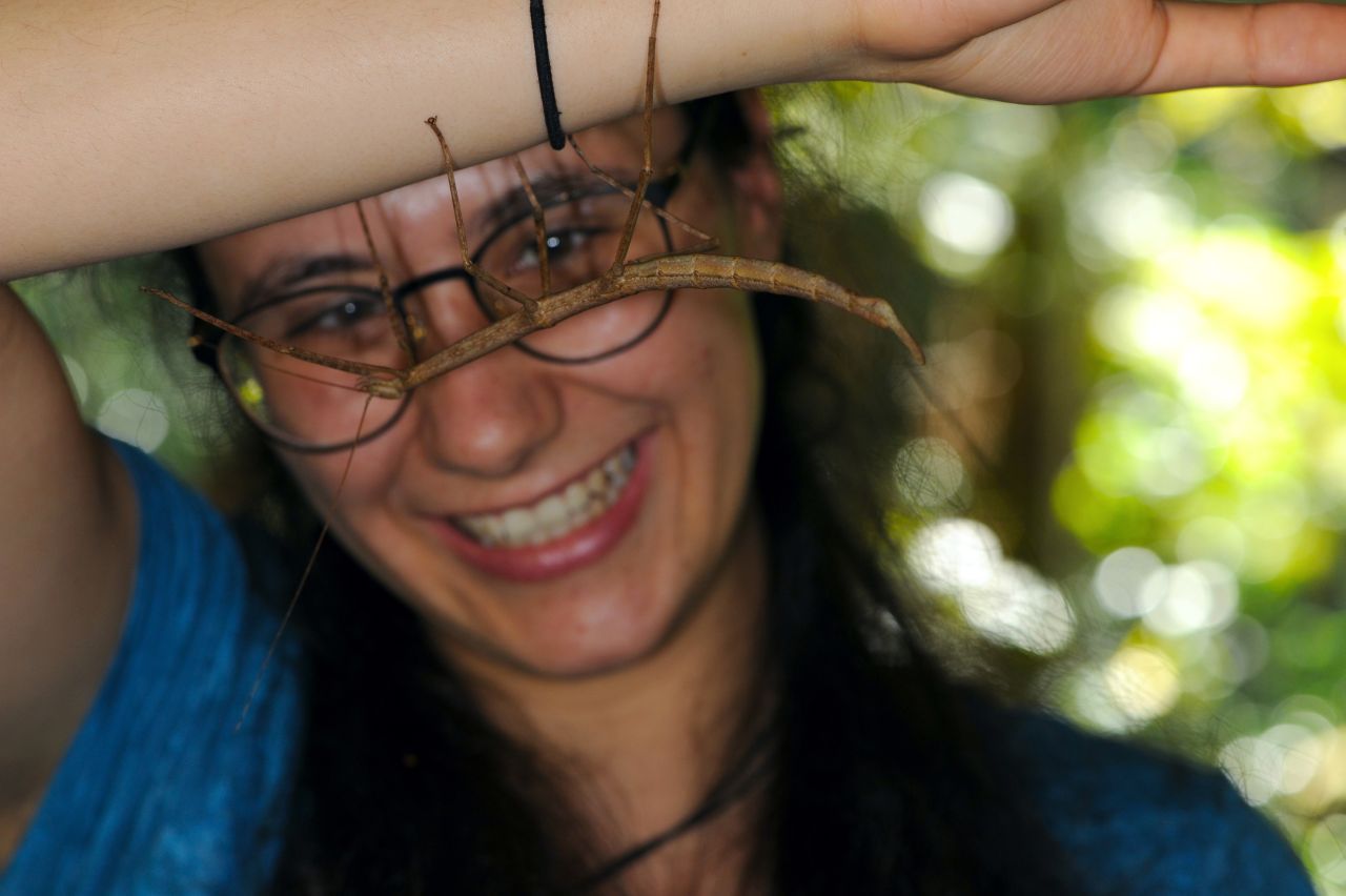 Francesca Ferrari posing with a stick insect on her arm.