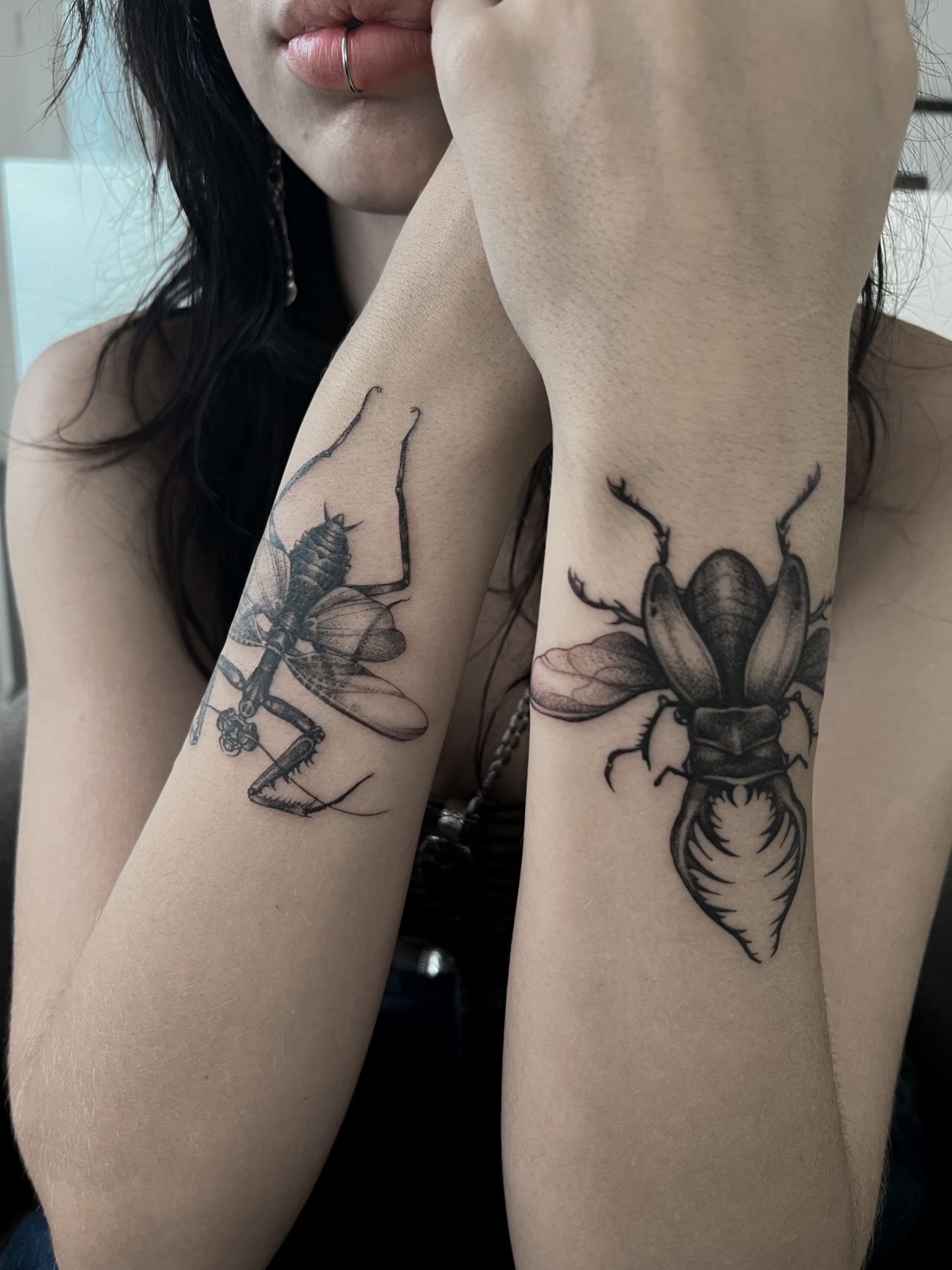 Praying mantis and stag beetle tattoos on the arms of one of Agata’s customers.