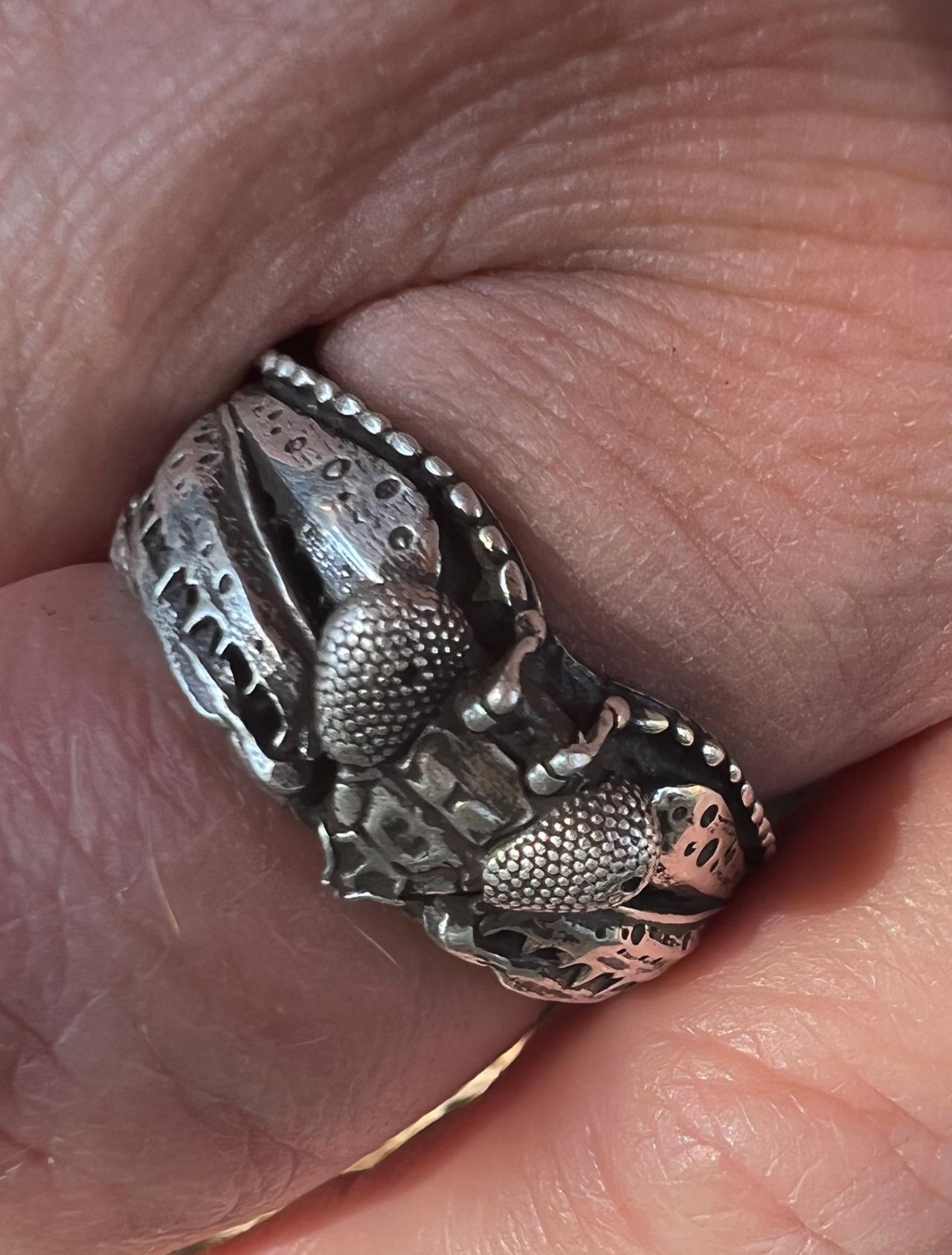 A praying mantis ring cast in silver.