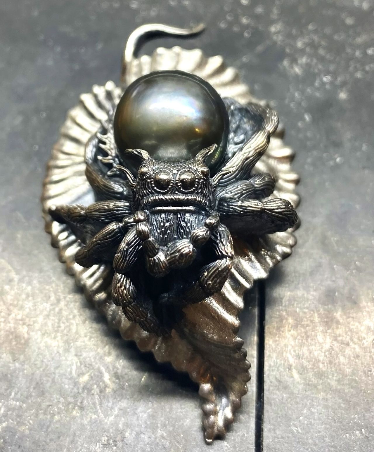 A jumping spider pendant with a Tahitian pearl as the abdomen.